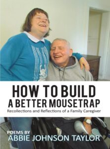 The cover image is a photo of Abbie and her husband Bill. Bill is sitting in a wheelchair wearing a gray hoodie and black sweatpants. He has short gray hair and wears a silver watch with a white face. His eyes are closed, and he is smiling. Standing beside him to the left is Abbie in a cerulean blue sweater with a white neckline and white cat sitting on a stack of white books. The cat has scratched the wall of blue. Abbie is also wearing blue jeans and white Crocs. She has short brown hair with bangs and is smiling, and her arm is around Bill’s shoulder. The rest of the cover includes the title and subtitle written in black letters inside a white banner, and the author’s name at the bottom.